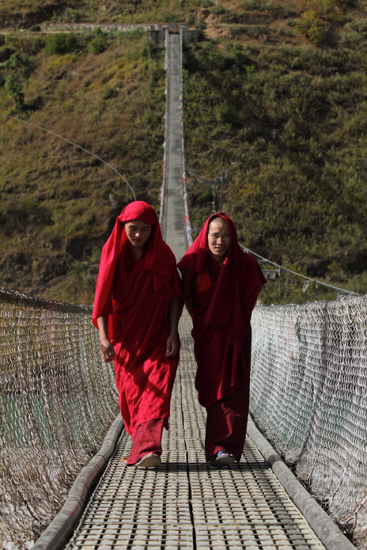 Punakha Valley suspension bridge bulit by ingenious locals above mountain river red-robed monks