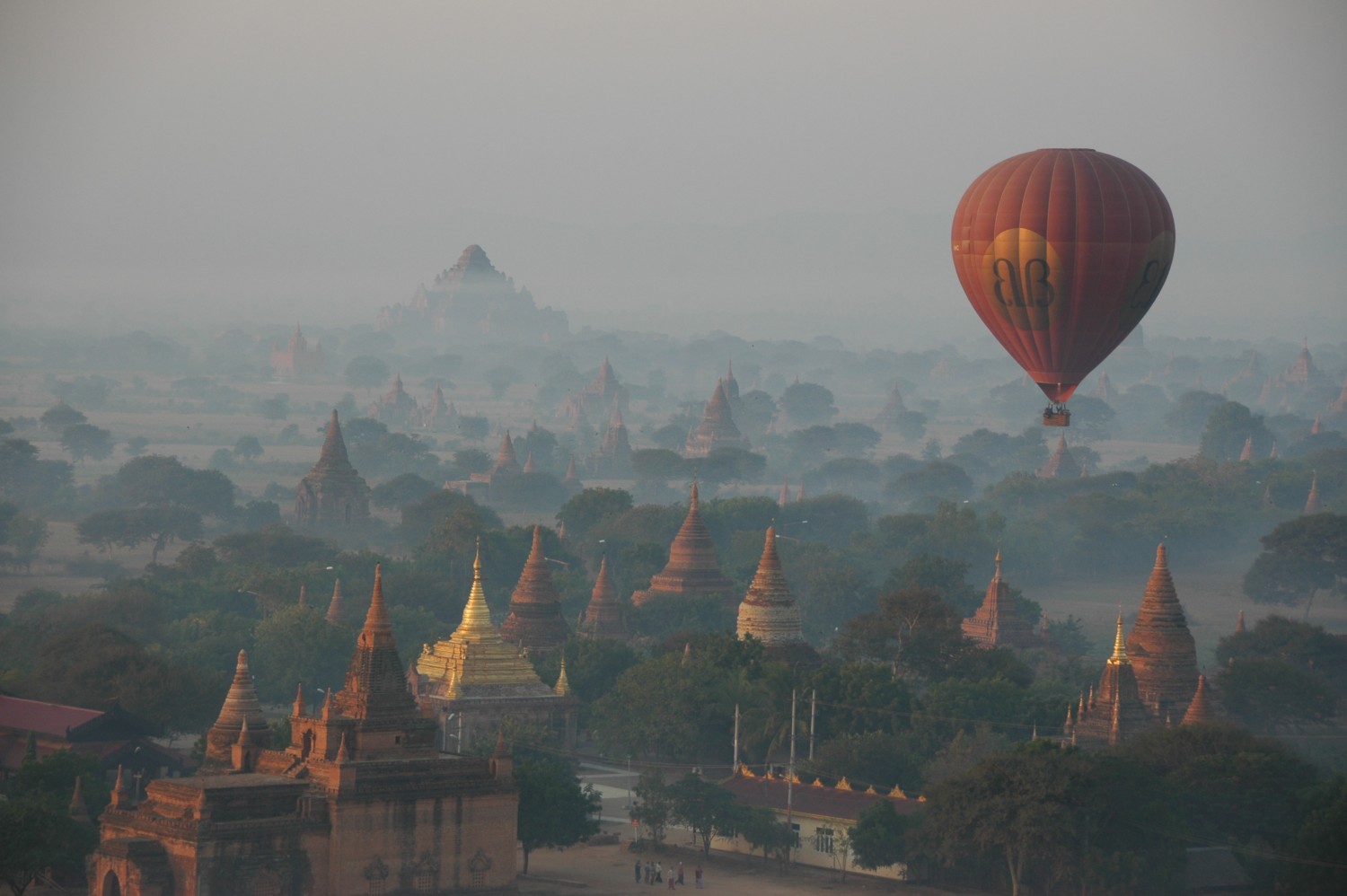 Hot-air balloons flying over mystical foggy Bagan Myanmar
