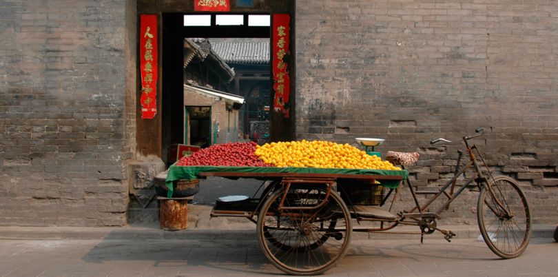 Loaded bicycle in front of a wall in Pingyao, China