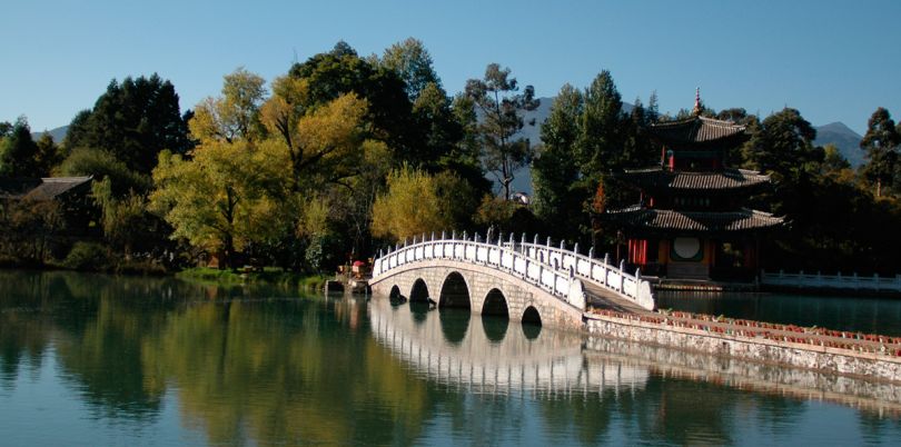 Bridge over lake in the mountains in Lijang China