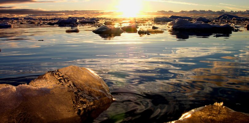 Sunset over rocks and water in Greenland