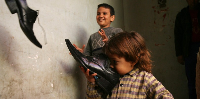 Boys sniffing and playing with shoes