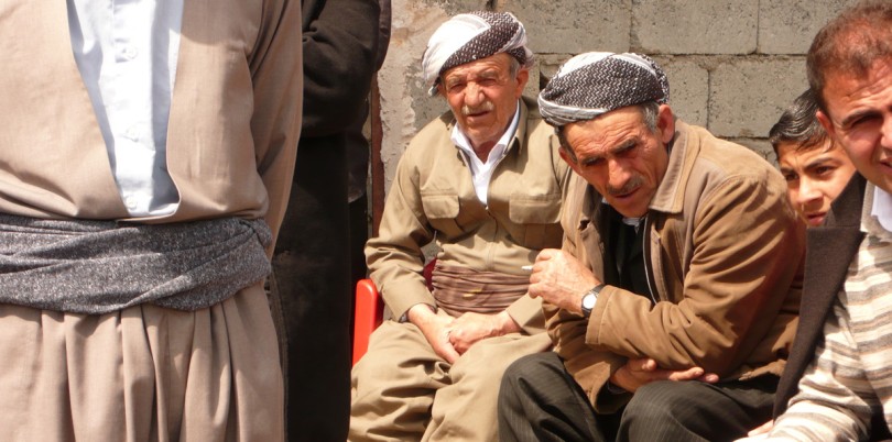 Iraqi men sitting outside on a bench