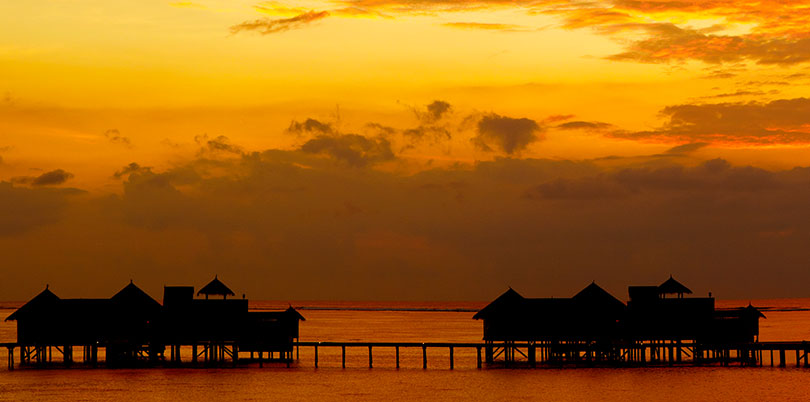 Maldives sunset wide ocean huts on stilts