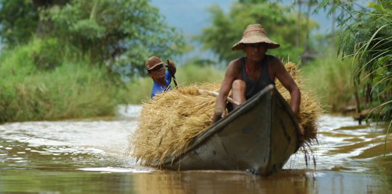 Two men in a boat with crops, Myanmar