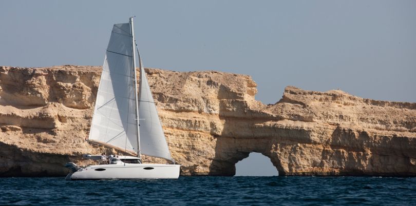 Yacht in the sea in front of rocks, Oman