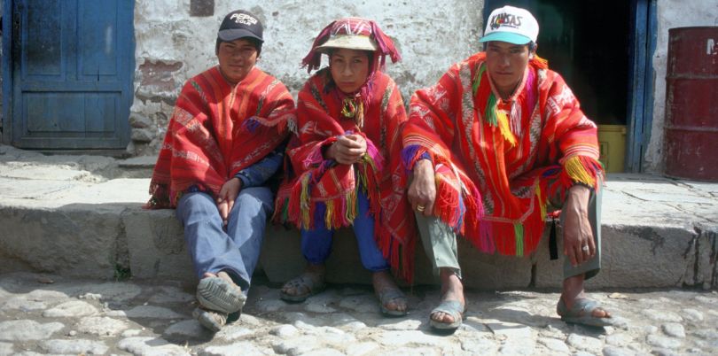 Poncho men sitting on pavement in Cusco Peru