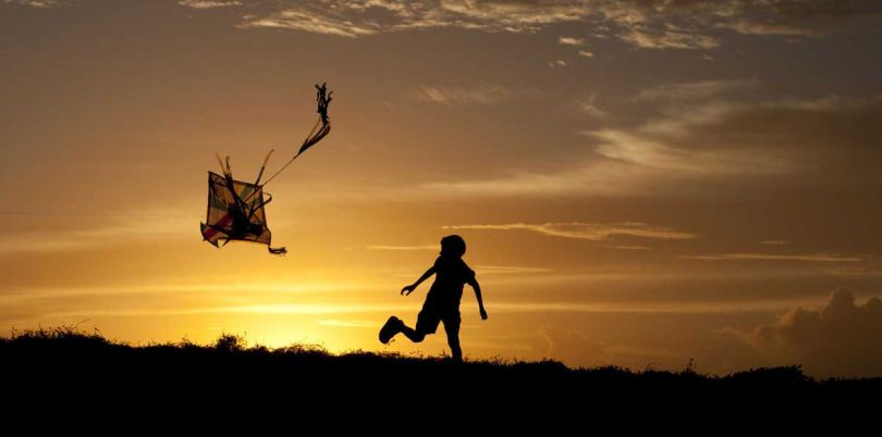 Child flying a kite in the sunset, Sri Lanka