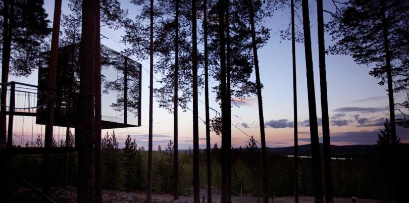 Mirror cube exterior at dusk the Tree Hotel in Sweden